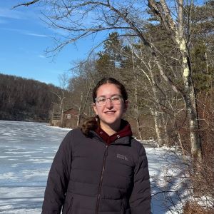 A college student standing smiling outside in snow